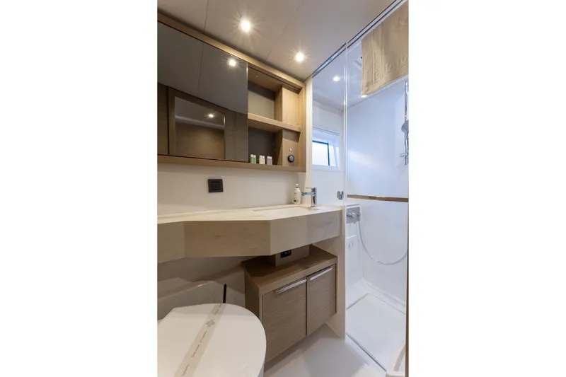 Aura Yacht Photos Pics Modern bathroom interior of 2024 Lagoon 46 yacht, featuring sleek design and ample storage.