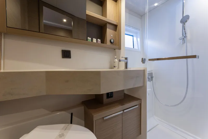 Aura Yacht Photos Pics Modern bathroom in 2024 Lagoon 46 yacht with shower and sleek fixtures.