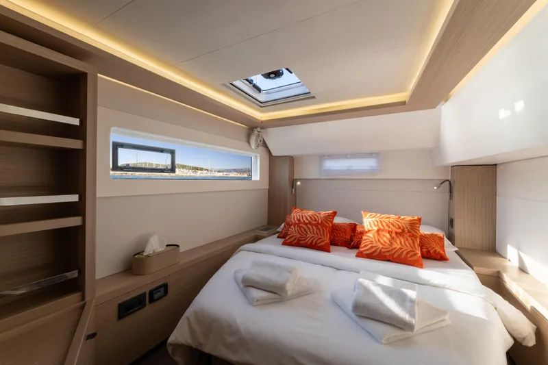 Aura Yacht Photos Pics Luxurious 2024 Lagoon 46 yacht cabin with modern design and vibrant orange accents.