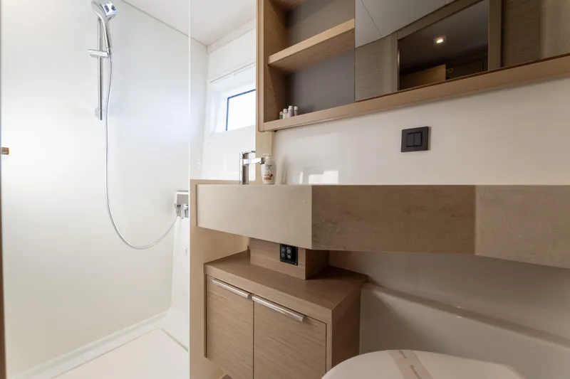 Aura Yacht Photos Pics Luxurious bathroom interior of 2024 Lagoon 46 yacht with modern fixtures and elegant design.
