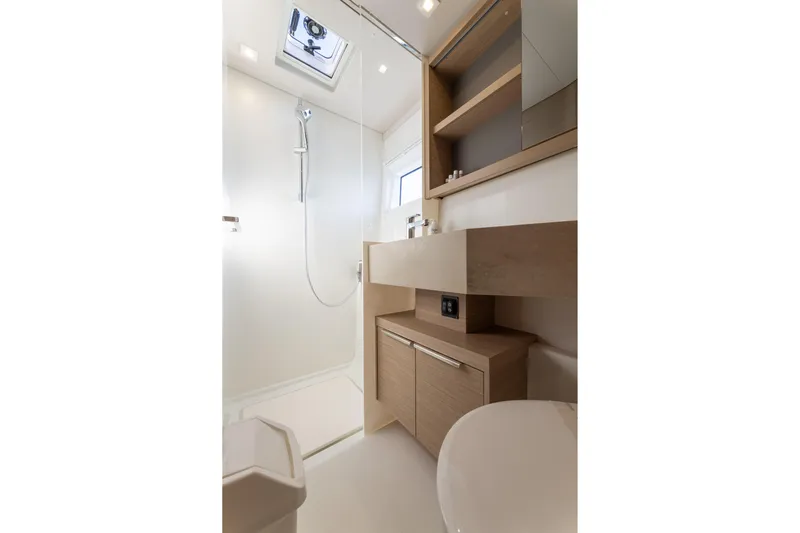 Aura Yacht Photos Pics Modern bathroom interior of 2024 Lagoon 46 yacht, featuring sleek design and wooden cabinetry.