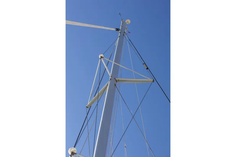 Aura Yacht Photos Pics Mast of 2024 Lagoon 46 sailboat against clear blue sky.