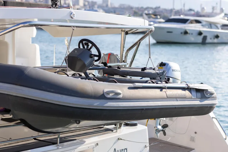 Aura Yacht Photos Pics 2024 Lagoon 46 yacht with a Highfield tender and Honda outboard motor.