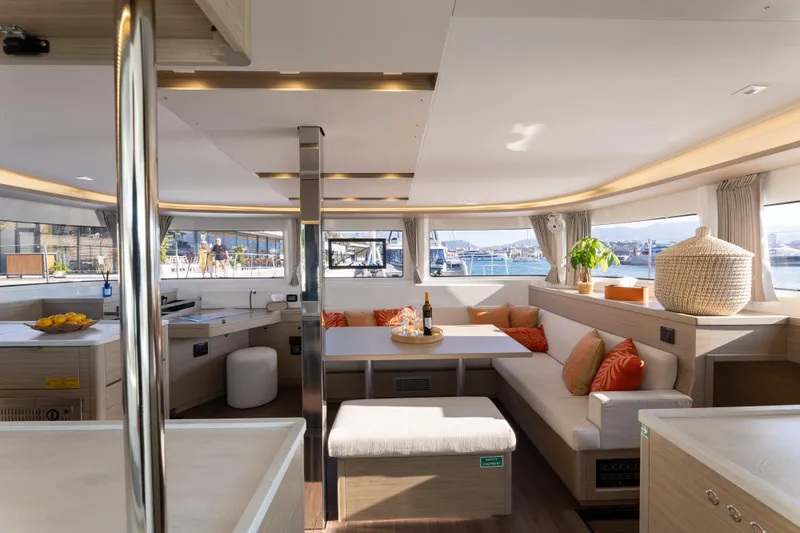 Aura Yacht Photos Pics Luxurious interior of 2024 Lagoon 46 catamaran with modern furnishings and panoramic windows.