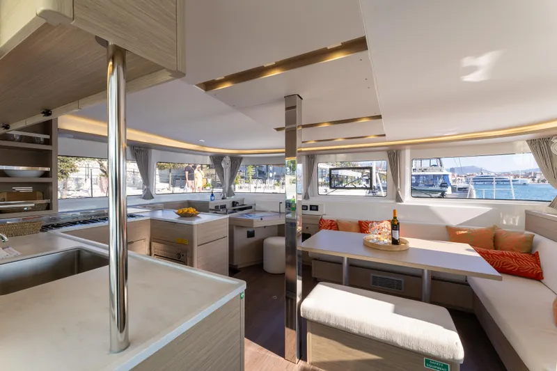 Aura Yacht Photos Pics Luxurious interior of 2024 Lagoon 46 catamaran with modern kitchen and seating area.