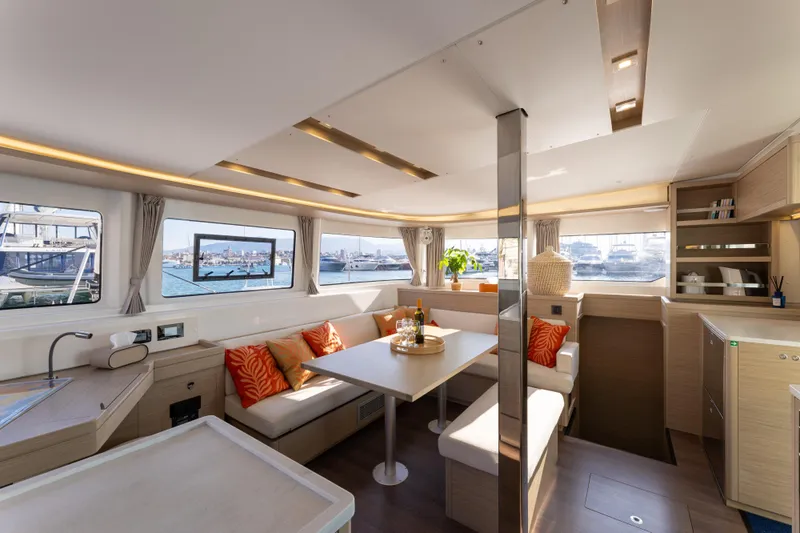 Aura Yacht Photos Pics Luxurious interior of 2024 Lagoon 46 catamaran with modern furnishings and panoramic windows.