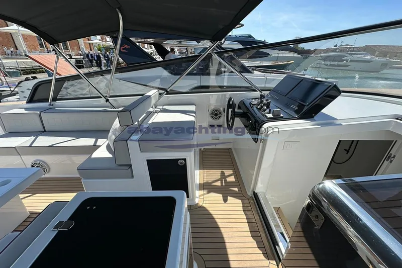 Yacht Photos Pics 2024 VanDutch 48 yacht cockpit with modern controls and seating, docked at marina.