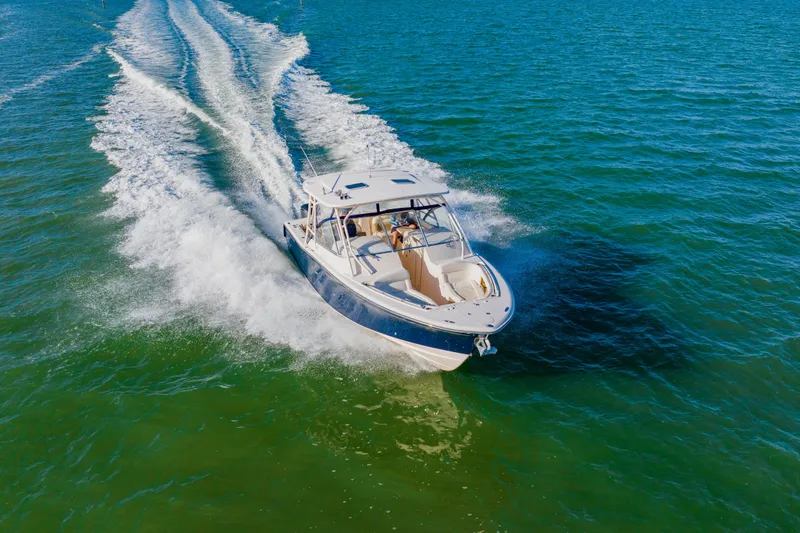  Yacht Photos Pics 2013 Grady-White Freedom 335 boat cruising on open water, creating a wake.