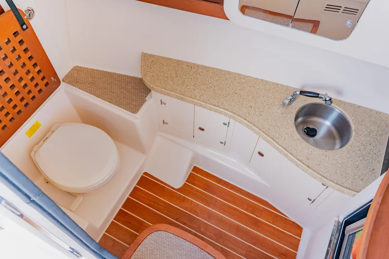  Yacht Photos Pics 2013 Grady-White Freedom 335 boat bathroom with sink, toilet, and wooden flooring.
