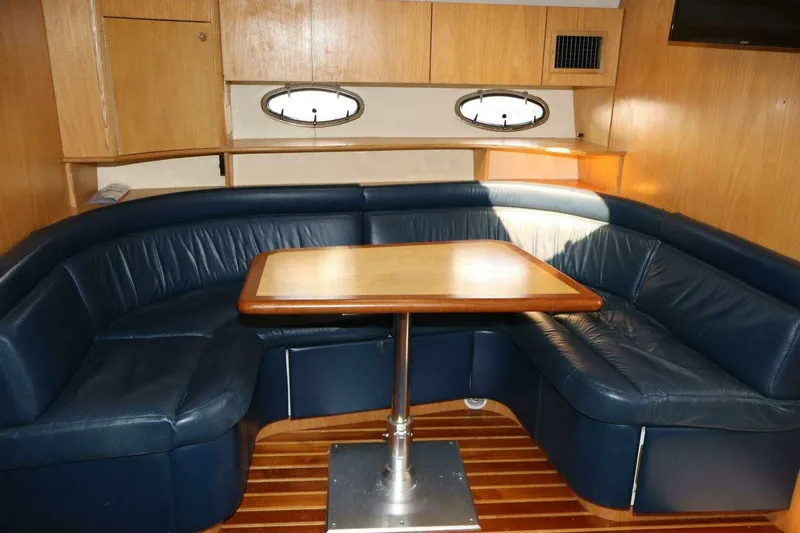  Yacht Photos Pics 2001 Tiara Yachts 4300 Open interior with blue leather seating and wooden table.