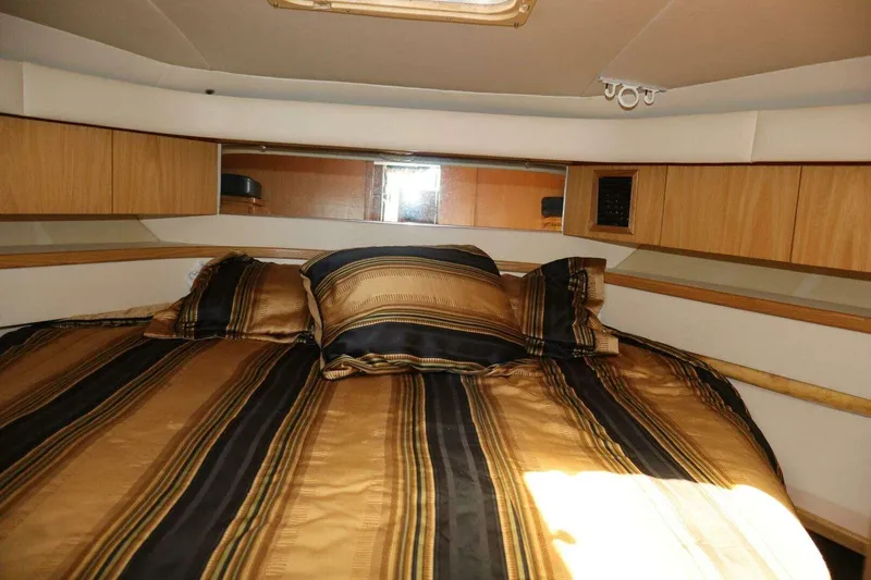  Yacht Photos Pics Luxurious cabin interior of 2001 Tiara Yachts 4300 Open with striped bedding.