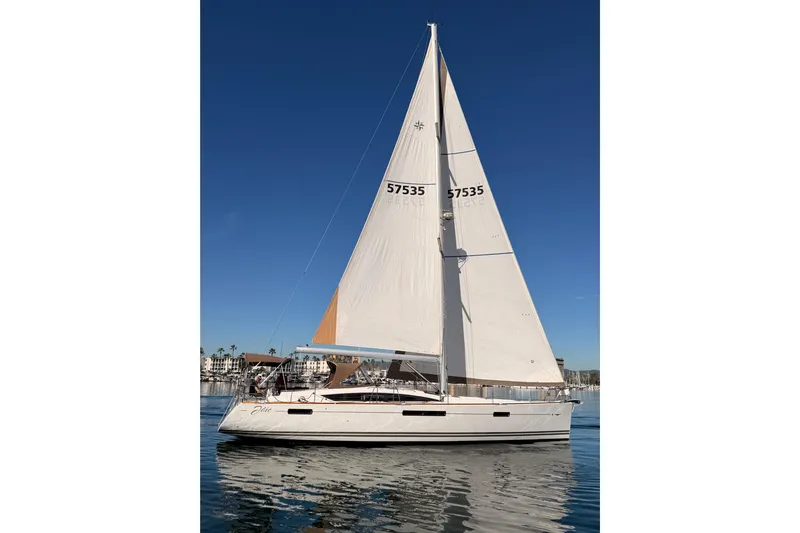 Joie Yacht Photos Pics 2011 Jeanneau 53 sailboat on calm water under clear blue sky.