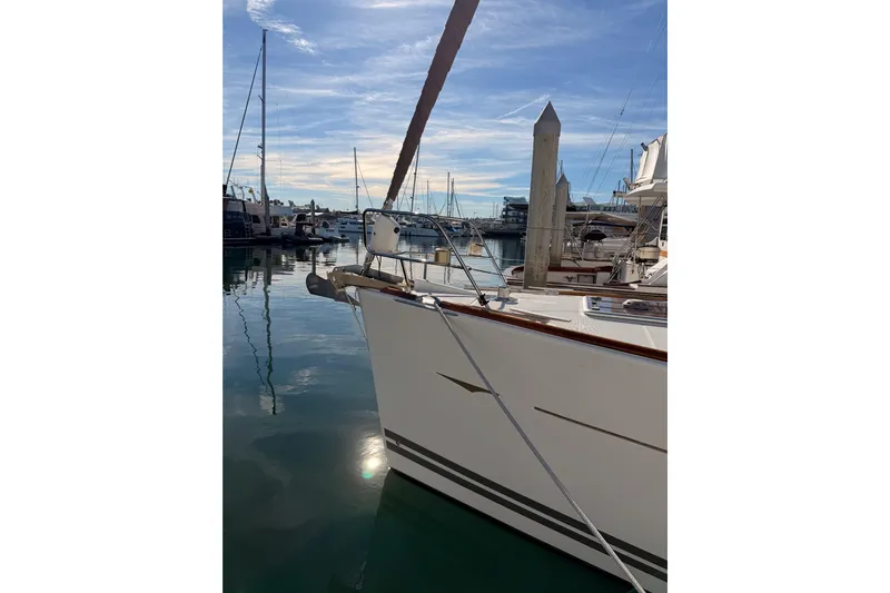 Joie Yacht Photos Pics 2011 Jeanneau 53 yacht docked in a serene marina under a clear blue sky.