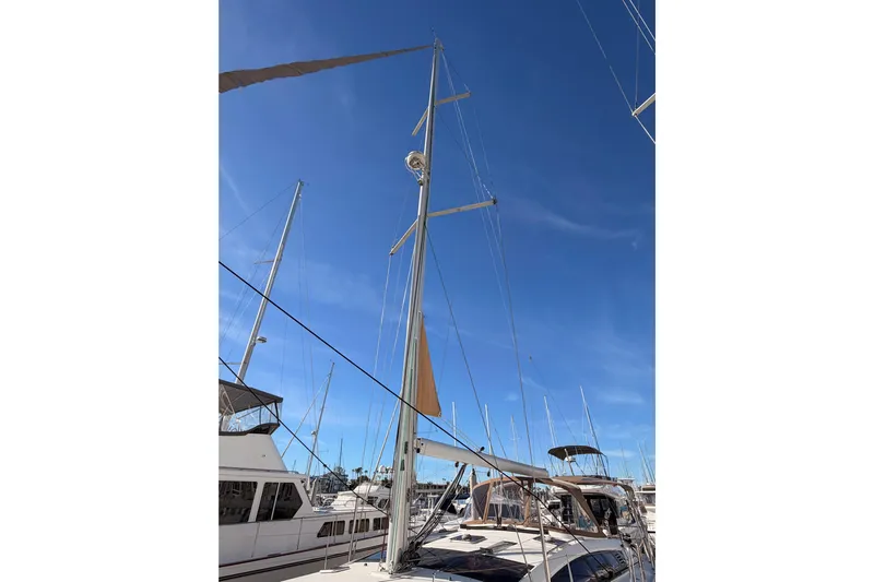Joie Yacht Photos Pics 2011 Jeanneau 53 sailboat with tall mast against clear blue sky.