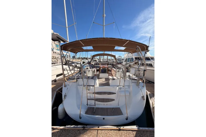 Joie Yacht Photos Pics 2011 Jeanneau 53 sailboat docked, featuring dual steering wheels and a spacious cockpit.