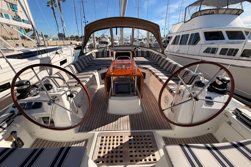 Joie Yacht Photos Pics Luxurious 2011 Jeanneau 53 sailboat cockpit with dual steering wheels and striped seating.