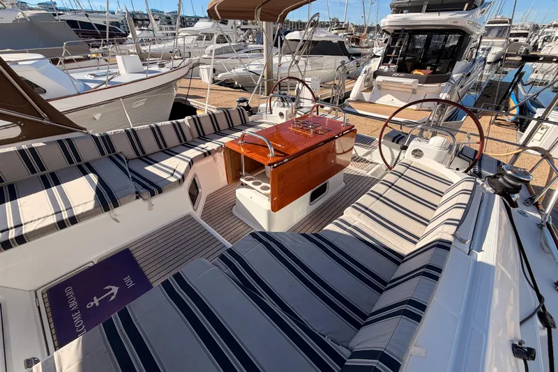 Joie Yacht Photos Pics 2011 Jeanneau 53 yacht interior with striped seating and wooden table at marina.