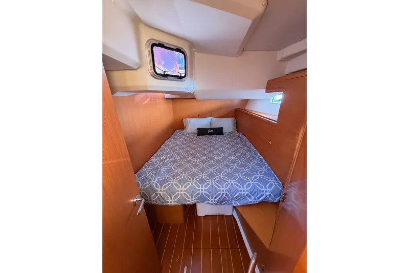 Joie Yacht Photos Pics Cozy cabin interior of 2011 Jeanneau 53 yacht with bed and porthole.