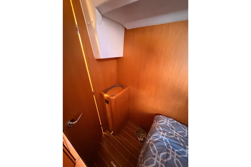 Joie Yacht Photos Pics Cozy cabin interior of 2011 Jeanneau 53 sailboat with wooden paneling and bedding.
