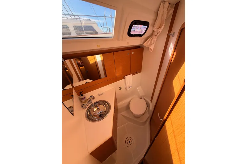 Joie Yacht Photos Pics 2011 Jeanneau 53 yacht bathroom with sink, toilet, and wooden cabinetry.