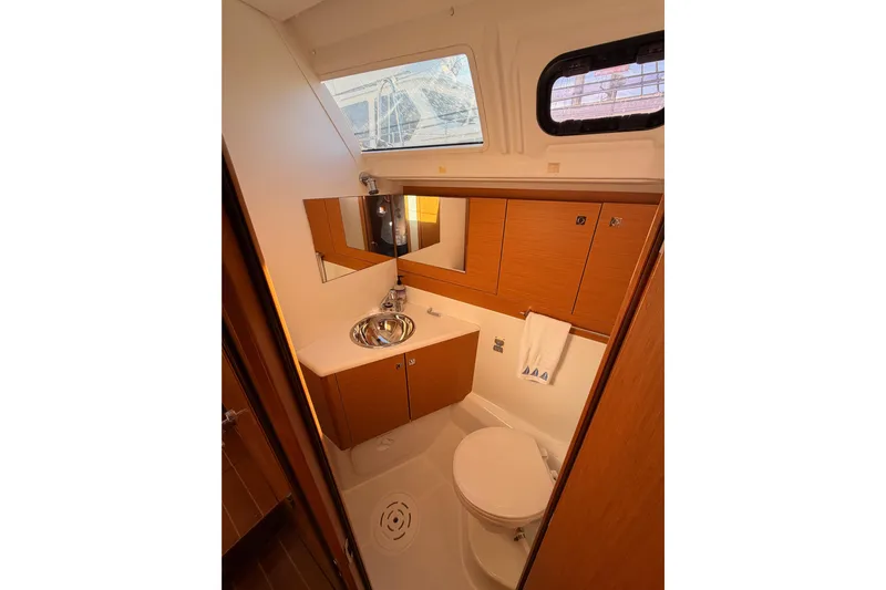 Joie Yacht Photos Pics Luxurious bathroom in a 2011 Jeanneau 53 yacht, featuring wood cabinetry and modern fixtures.