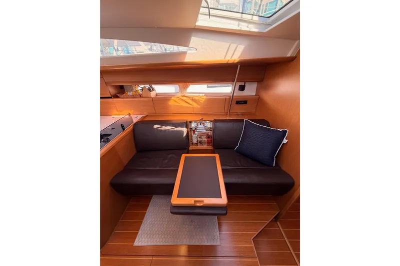 Joie Yacht Photos Pics Interior of 2011 Jeanneau 53 yacht with cozy seating and wooden finishes.