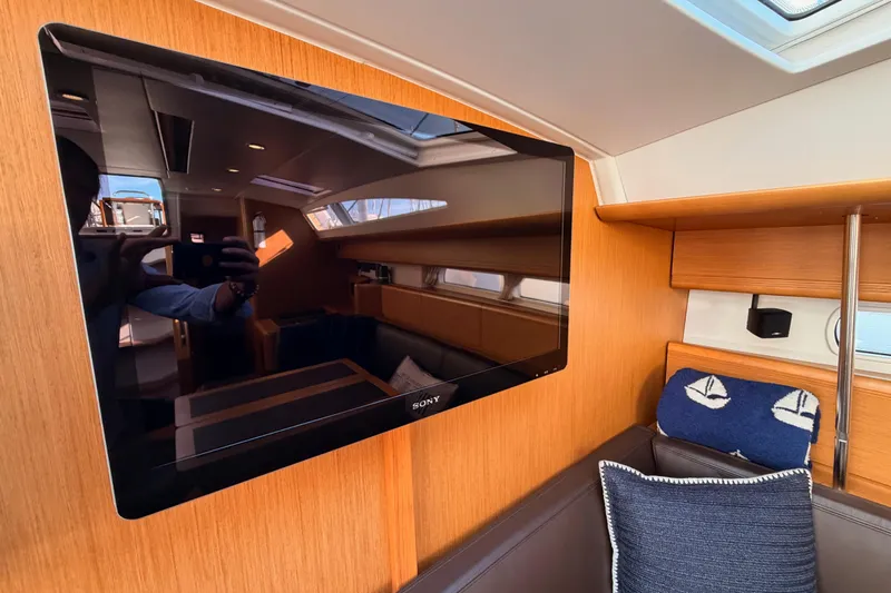 Joie Yacht Photos Pics Interior of 2011 Jeanneau 53 yacht with wall-mounted Sony TV and cozy seating area.