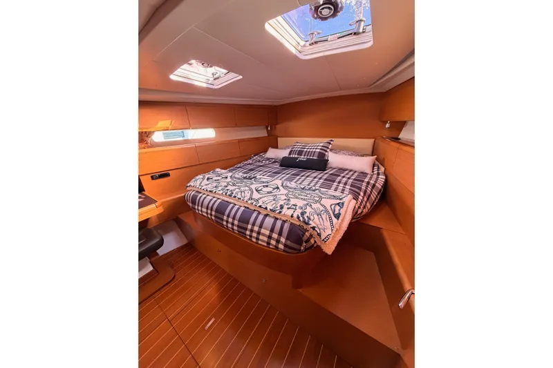 Joie Yacht Photos Pics Luxurious cabin interior of 2011 Jeanneau 53 yacht with cozy bedding and wooden finish.