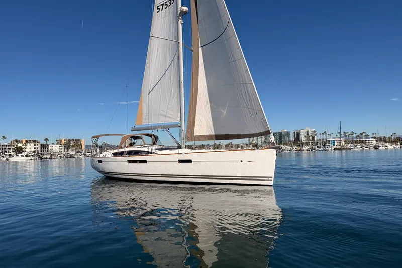 Joie Yacht Photos Pics 2011 Jeanneau 53 sailboat on calm water with marina backdrop.
