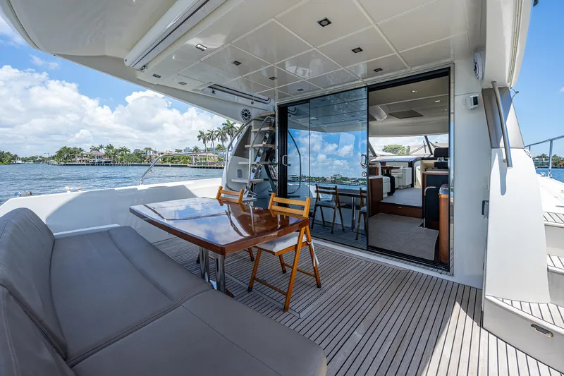  Yacht Photos Pics Luxurious 2014 Prestige 550 yacht deck with seating and dining area, overlooking serene waters.