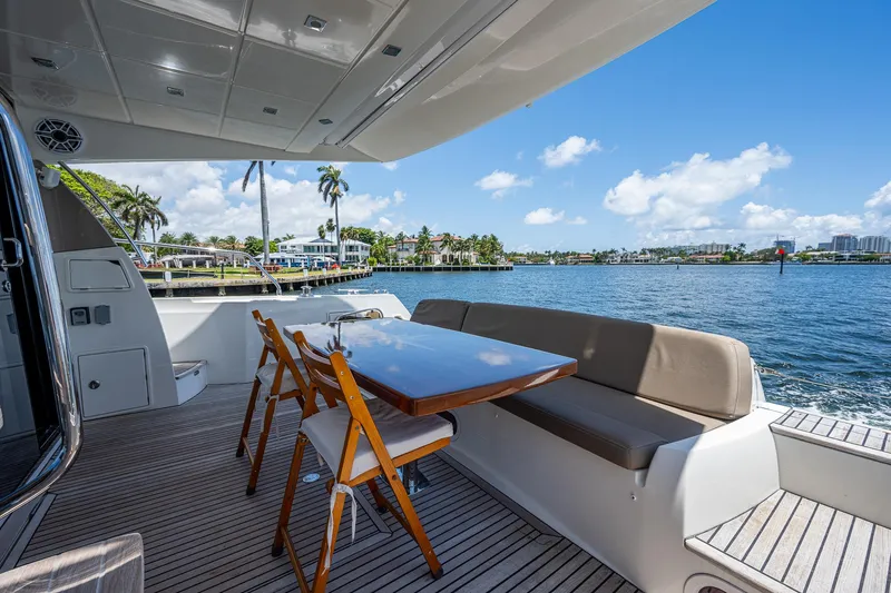  Yacht Photos Pics Luxury yacht deck with seating area, Prestige 550, 2014 model, overlooking scenic waterfront.