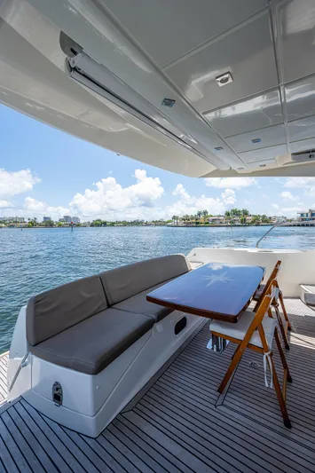  Yacht Photos Pics Luxury yacht deck with seating and table, Prestige 550, 2014 model, overlooking serene waters.
