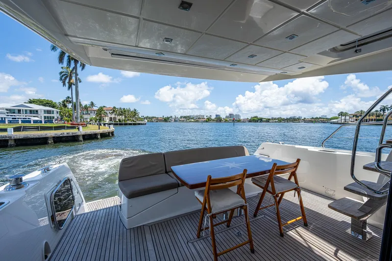  Yacht Photos Pics Luxury yacht deck with seating, table, and scenic waterfront view. Prestige 550, 2014 model.