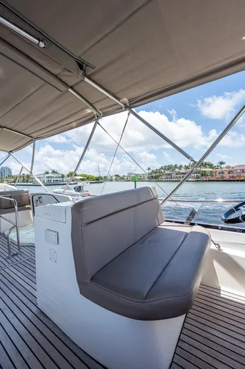  Yacht Photos Pics 2014 Prestige 550 yacht deck with seating, under canopy, on a sunny day.