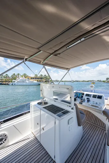  Yacht Photos Pics 2014 Prestige 550 yacht interior with outdoor kitchen and helm, overlooking scenic waterfront.