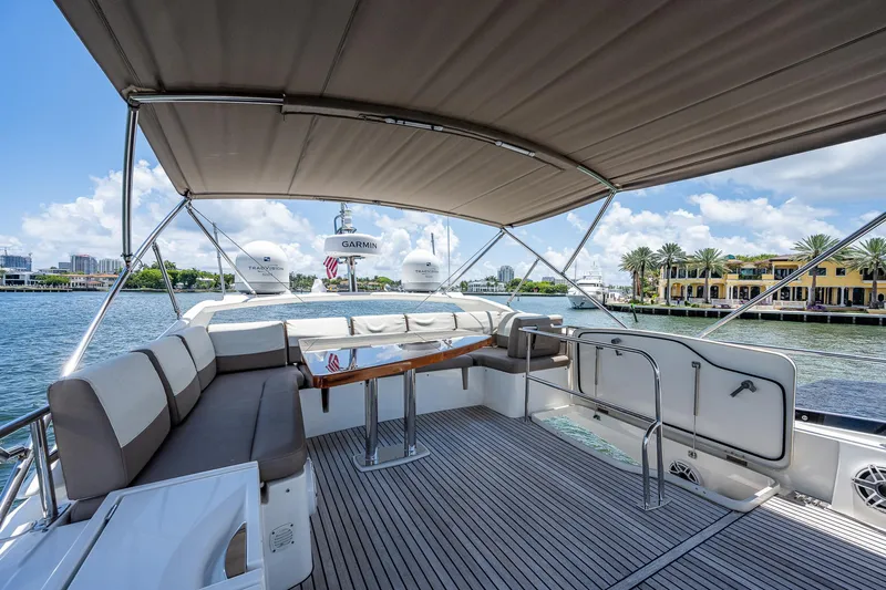  Yacht Photos Pics Luxurious 2014 Prestige 550 yacht deck with seating, table, and scenic waterfront view.