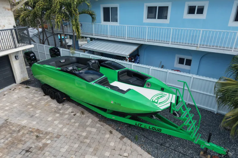  Yacht Photos Pics Green 2021 E-Ticket 29 boat on trailer, parked in a residential driveway.