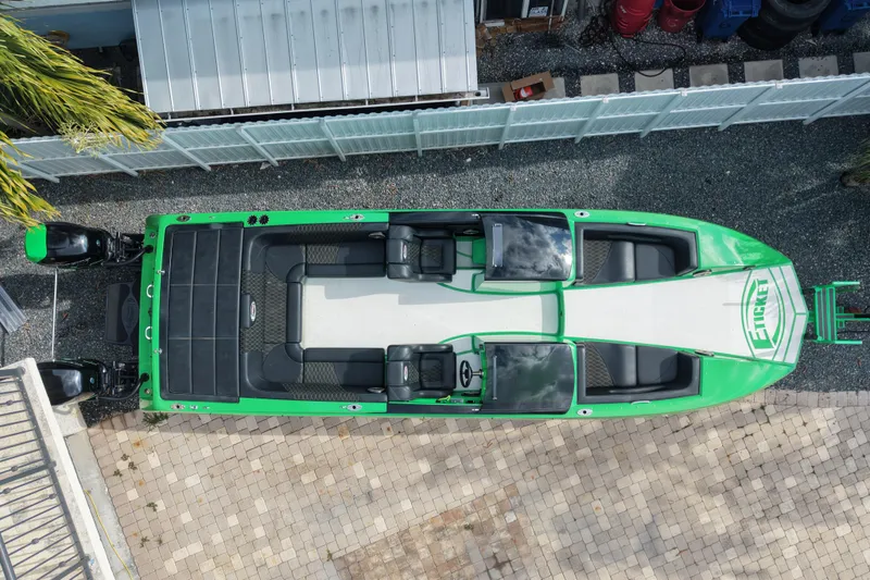  Yacht Photos Pics Aerial view of a 2021 E-Ticket 29 boat with green accents, docked on a paved surface.