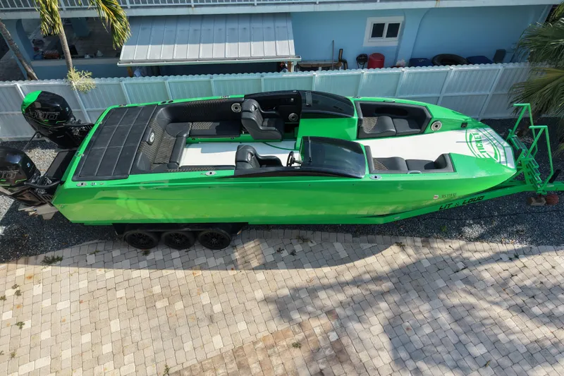  Yacht Photos Pics Green 2021 E-Ticket 29 boat with dual engines, parked on a paved driveway.
