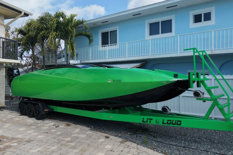  Yacht Photos Pics Green 2021 E-Ticket 29 boat on trailer in front of blue house.