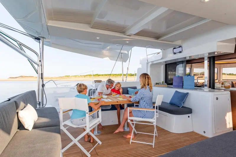  Yacht Photos Pics Family enjoying leisure time on a 2021 Lagoon 46 catamaran's deck.