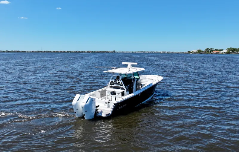  Yacht Photos Pics 2024 Blackfin 332 CC boat cruising on open water under clear blue sky.