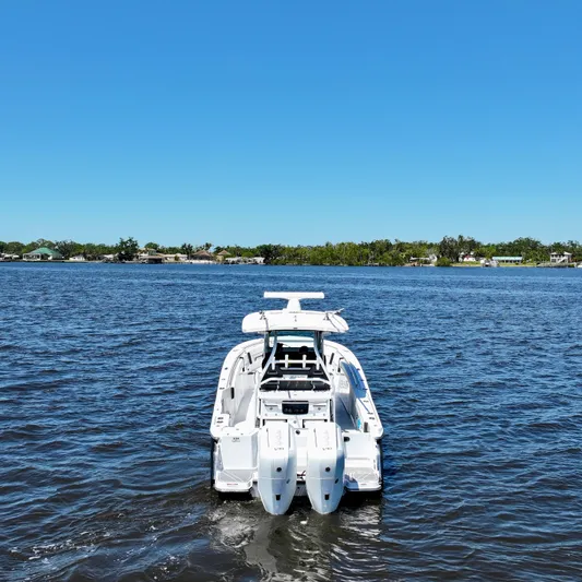  Yacht Photos Pics 2024 Blackfin 332 CC boat on calm water under clear blue sky.
