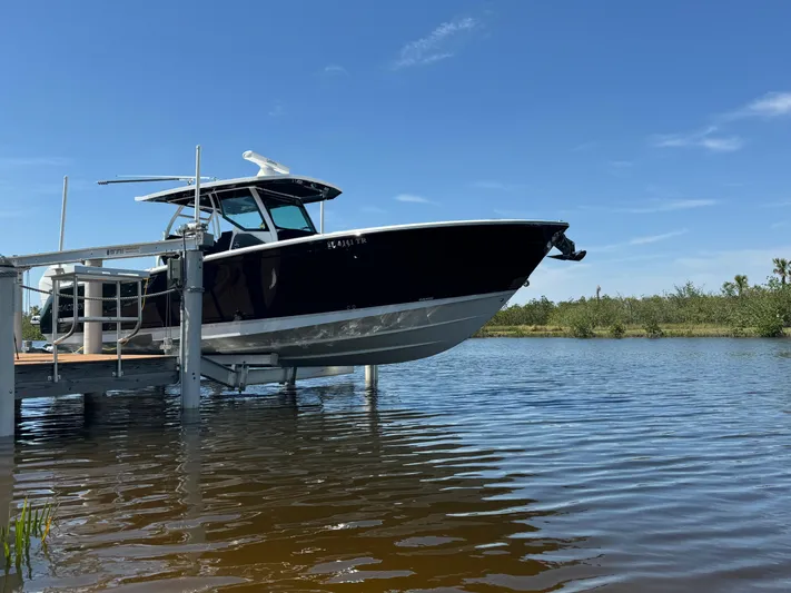  Yacht Photos Pics 2024 Blackfin 332 CC boat docked on a sunny day by the water.