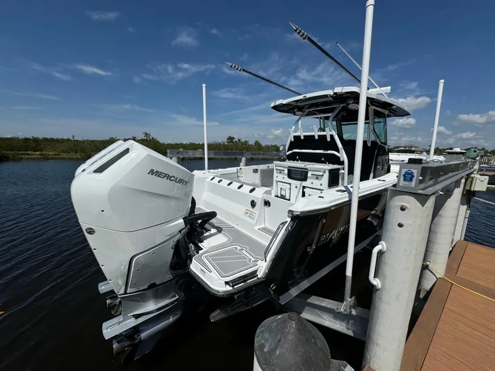  Yacht Photos Pics 2024 Blackfin 332 CC boat docked with Mercury outboard engines, under clear blue sky.