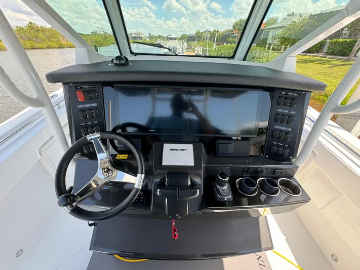  Yacht Photos Pics 2024 Blackfin 332 CC boat dashboard with steering wheel and control panel.
