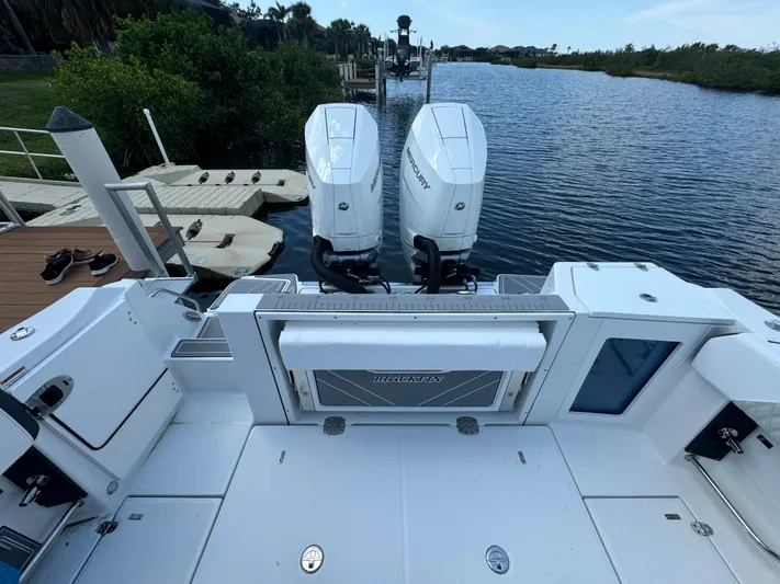 Yacht Photos Pics 2024 Blackfin 332 CC boat with twin outboard engines docked by a serene waterway.