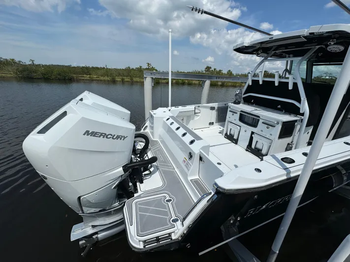  Yacht Photos Pics 2024 Blackfin 332 CC boat with Mercury engine, docked on a calm waterway.
