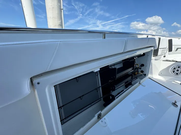  Yacht Photos Pics 2024 Blackfin 332 CC boat with open storage compartment under clear blue sky.