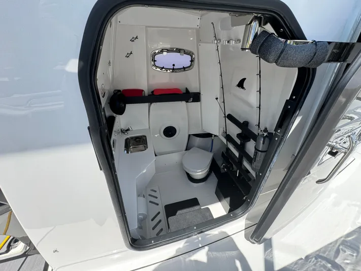  Yacht Photos Pics 2024 Blackfin 332 CC boat cabin interior with toilet and fishing rod storage.
